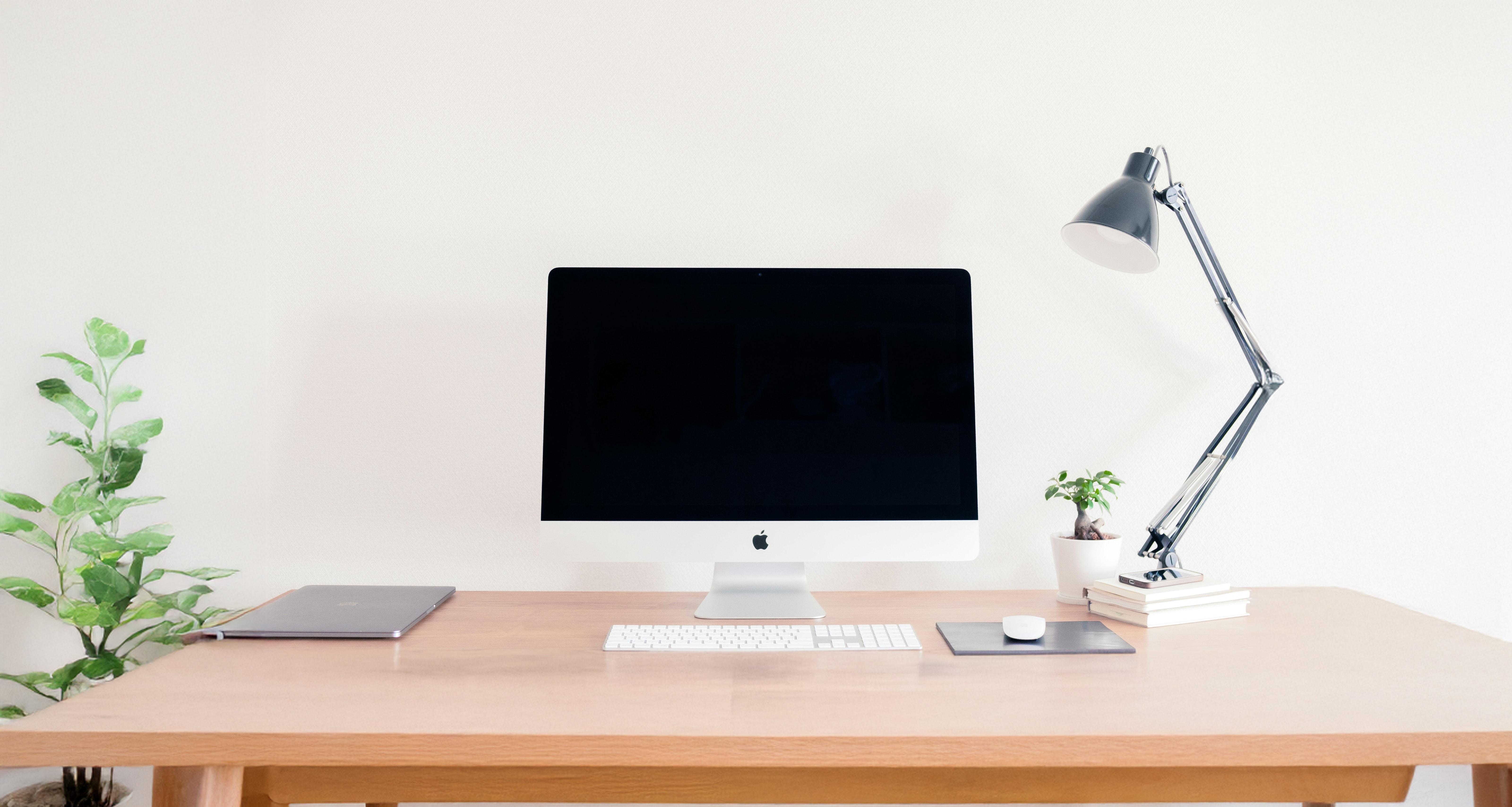 A silver iMac on a wooden desk